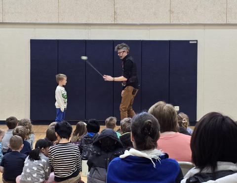 Mark Hayward with a child volunteer spinning a yo-yo in front of the child.